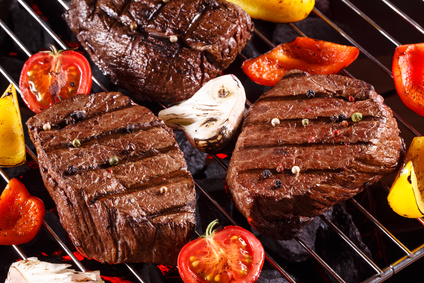 Beef steak on a barbecue grill with vegetables